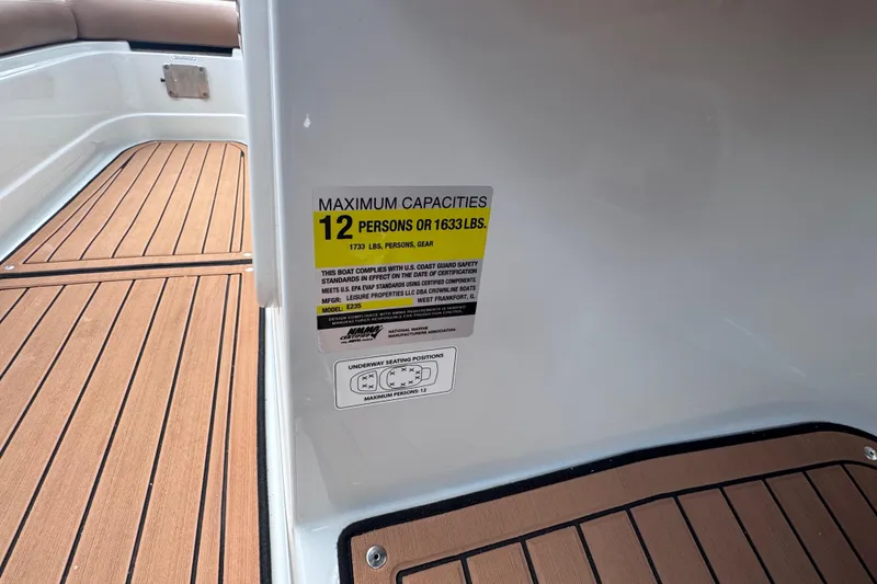 Slide: The Image of 2025 Crownline Eclipse E235 boat capacity label, seating for 12, 1633 lbs limit. - 26