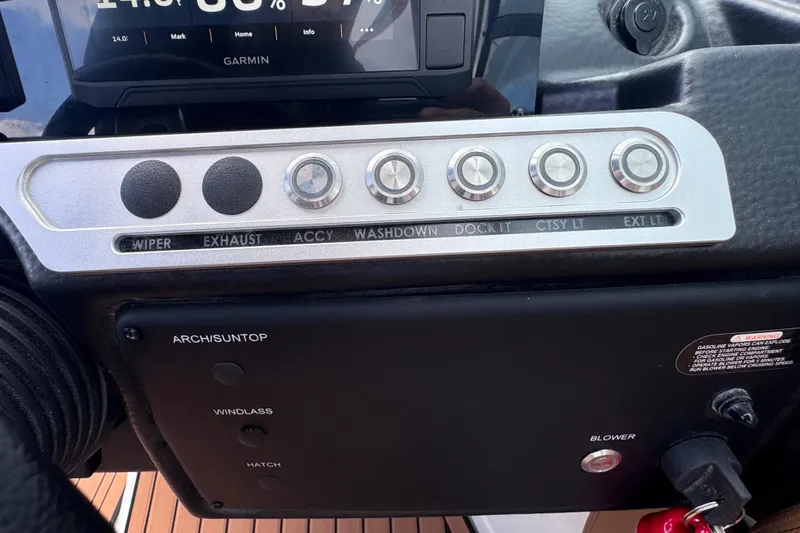Slide: The Image of Dashboard controls of a 2025 Crownline Eclipse E235 boat with labeled buttons and switches. - 27