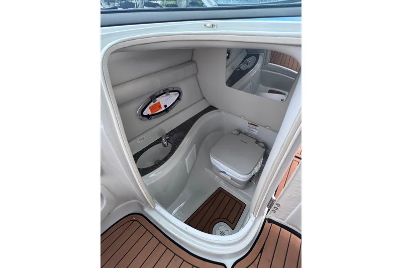 Slide: The Image of 2025 Crownline Eclipse E235 boat interior with compact bathroom amenities. - 28