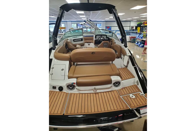 Slide: The Image of 2025 Crownline Eclipse E235 boat interior with tan seating and wood-style flooring. - 5