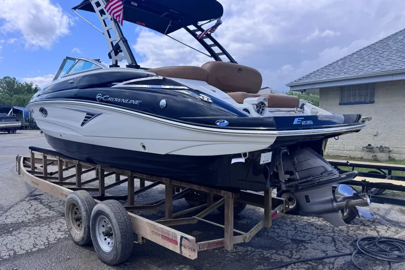 Slide: The Image of 2025 Crownline Eclipse E235 boat on trailer, showcasing sleek design and modern features. - 7