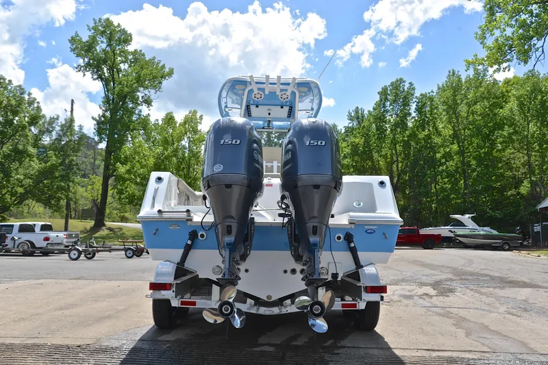 Slide: The Image of 2021 Tidewater 256 CC Adventure boat with dual Yamaha 150 engines, parked outdoors. - 14