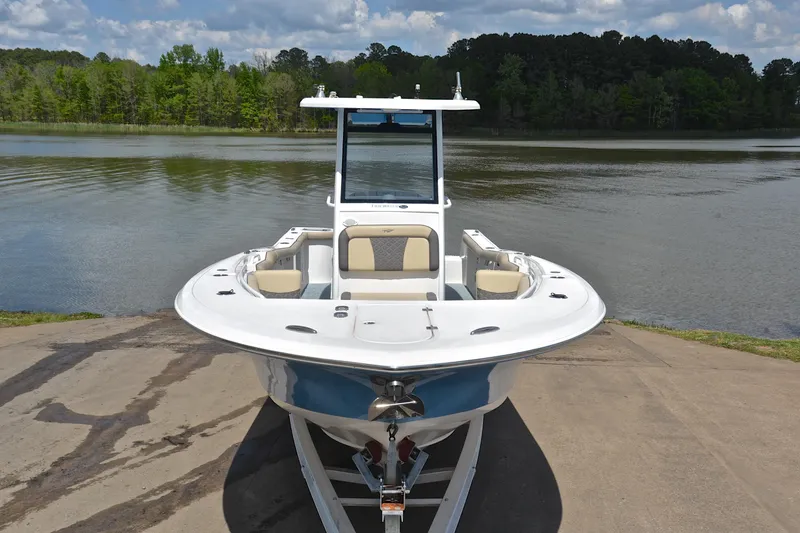 Slide: The Image of 2021 Tidewater 256 CC Adventure boat on trailer by a scenic lake. - 18