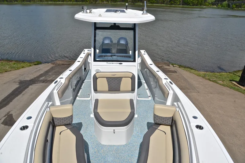 Slide: The Image of 2021 Tidewater 256 CC Adventure boat with spacious seating, docked by a serene lake. - 22