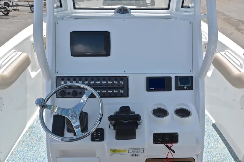 Slide: The Image of 2021 Tidewater 256 CC Adventure boat dashboard with steering wheel and electronic controls. - 26