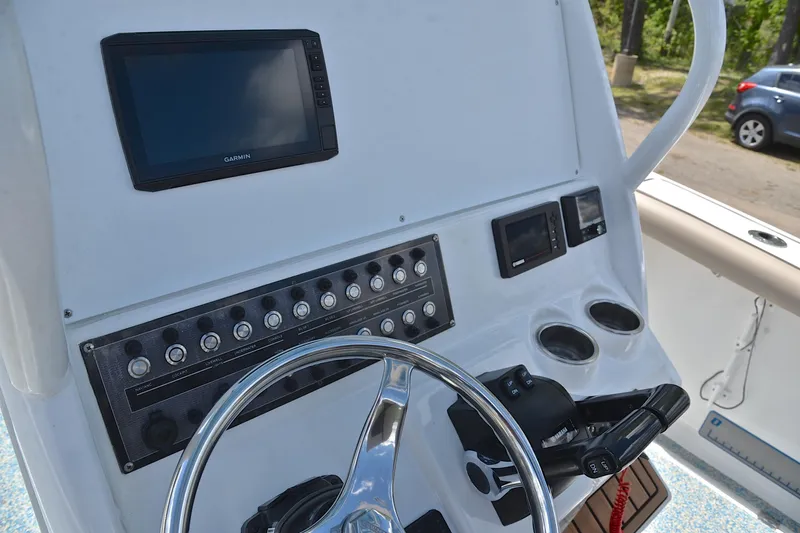 Slide: The Image of 2021 Tidewater 256 CC Adventure boat dashboard with Garmin display and control panel. - 27