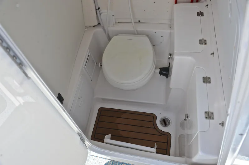 Slide: The Image of 2021 Tidewater 256 CC Adventure boat bathroom with toilet and wooden floor mat. - 30