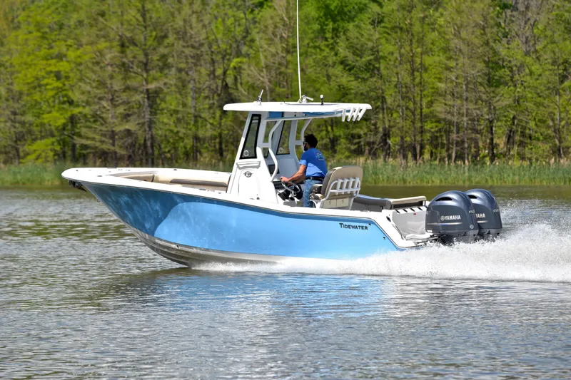 Slide: The Image of 2021 Tidewater 256 CC Adventure boat cruising on a lake with twin Yamaha engines. - 4