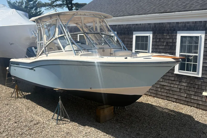 The Image of 2017 Grady-White Freedom 235 boat on stands, near a shingled building. - 0