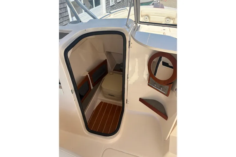 Slide: The Image of 2017 Grady-White Freedom 235 boat cabin interior with seating and storage. - 9