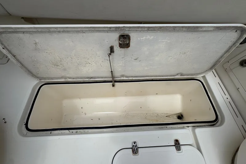 Slide: The Image of Open storage compartment on a 2006 Pursuit 3480 Center Console boat. - 18