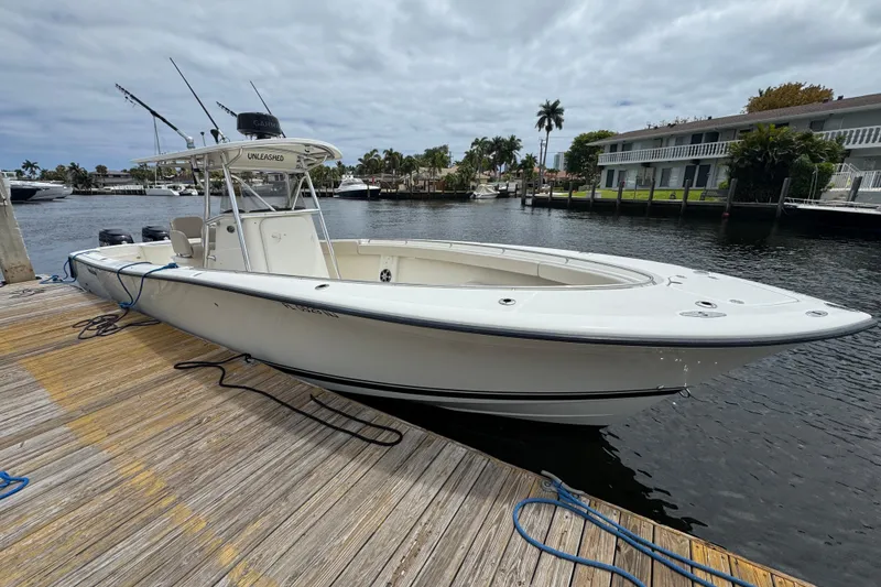 Slide: The Image of 2006 Pursuit 3480 Center Console boat docked by waterfront homes. - 2