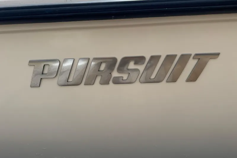 Slide: The Image of 2006 Pursuit 3480 Center Console boat logo on beige surface. - 27