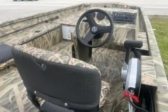 Slide: The Image of 2026 Crestliner 1760 Retriever SC boat interior with camo design and steering console. - 7