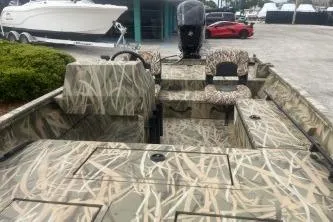 Slide: The Image of 2026 Crestliner 1760 Retriever SC boat with camouflage design, parked outdoors. - 9