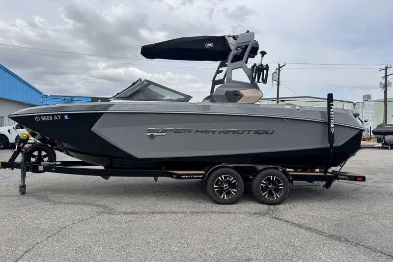The Image of 2019 Nautique Super Air Nautique G23 boat on trailer, parked outdoors. - 1