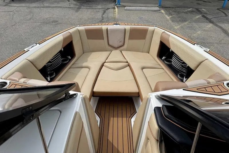 Slide: The Image of 2019 Nautique Super Air Nautique G23 boat interior with tan seating and wood flooring. - 17