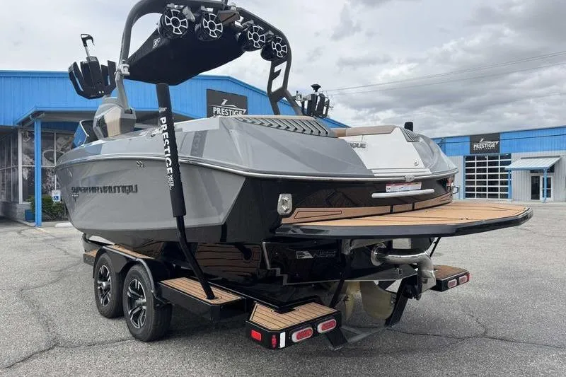 Slide: The Image of 2019 Nautique Super Air Nautique G23 boat on trailer, parked outside a blue building. - 5