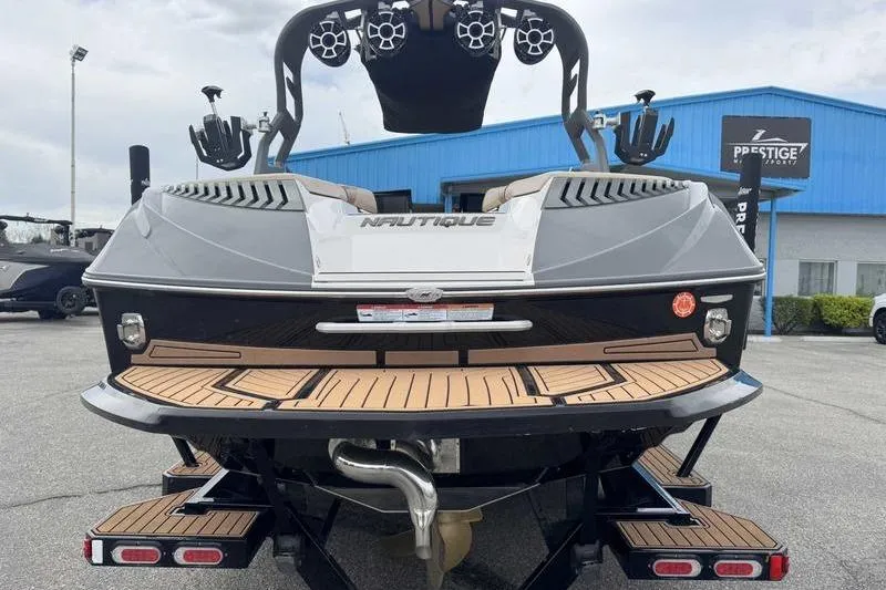 Slide: The Image of 2019 Nautique Super Air Nautique G23 boat rear view at dealership. - 7