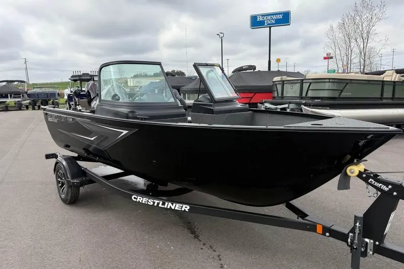 Slide: The Image of 2026 Crestliner 1650 Kodiak boat on trailer, parked outdoors near Rodeway Inn. - 2