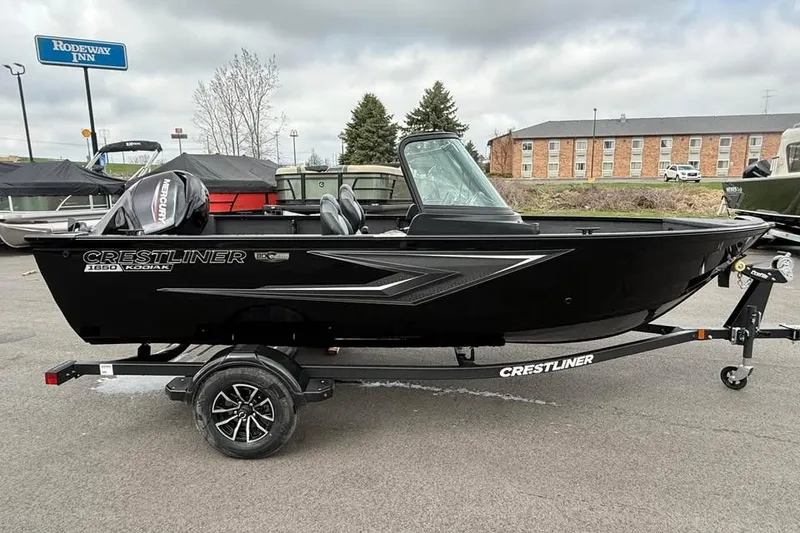 Slide: The Image of 2026 Crestliner 1650 Kodiak boat on trailer, parked outdoors near Rodeway Inn. - 3