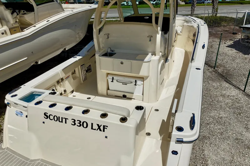 Slide: The Image of 2026 Scout 330 LXF boat interior, showcasing spacious deck and seating area. - 19
