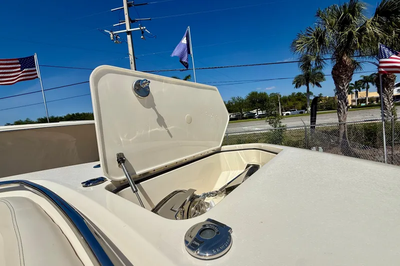 Slide: The Image of 2026 Scout 330 LXF boat anchor compartment open under clear blue sky. - 22