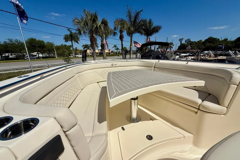 Slide: The Image of Luxurious seating area on 2026 Scout 330 LXF boat with table and cup holders. - 26