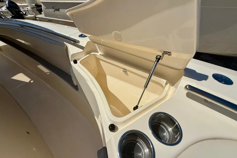 Slide: The Image of Open storage compartment on 2026 Scout 330 LXF boat with cup holders. - 32
