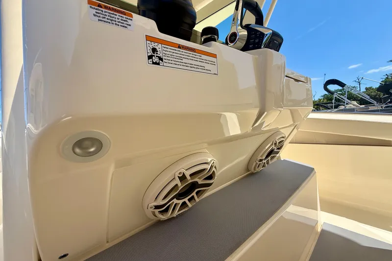 Slide: The Image of 2026 Scout 330 LXF boat console with speakers and warning labels. - 38