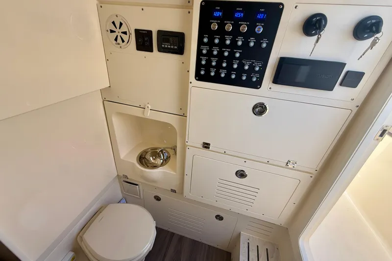 Slide: The Image of 2026 Scout 330 LXF boat interior with control panel, sink, and toilet. - 43