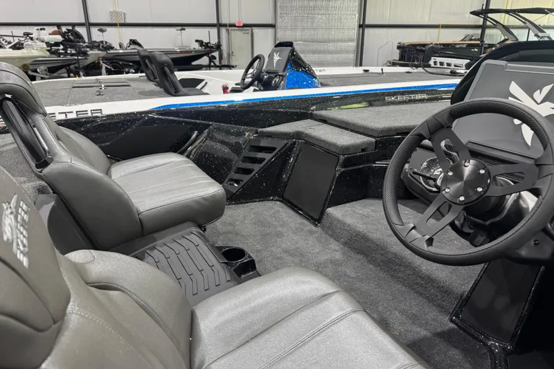Slide: The Image of 2026 Skeeter ZXR21 SE boat interior with steering wheel and seating. - 13