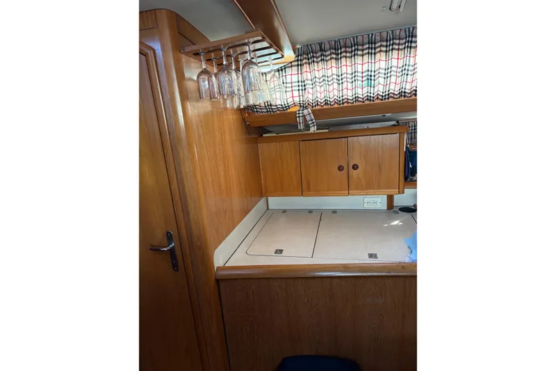 Slide: The Image of Interior of 2001 Jeanneau Sun Odyssey 45.2 yacht with wooden cabinetry and hanging wine glasses. - 11