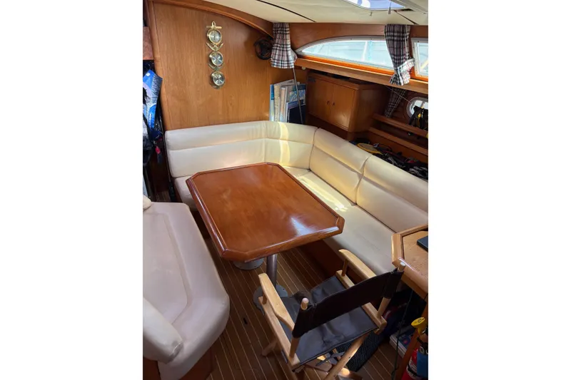 Slide: The Image of Interior of 2001 Jeanneau Sun Odyssey 45.2 yacht with cozy seating and wooden table. - 2