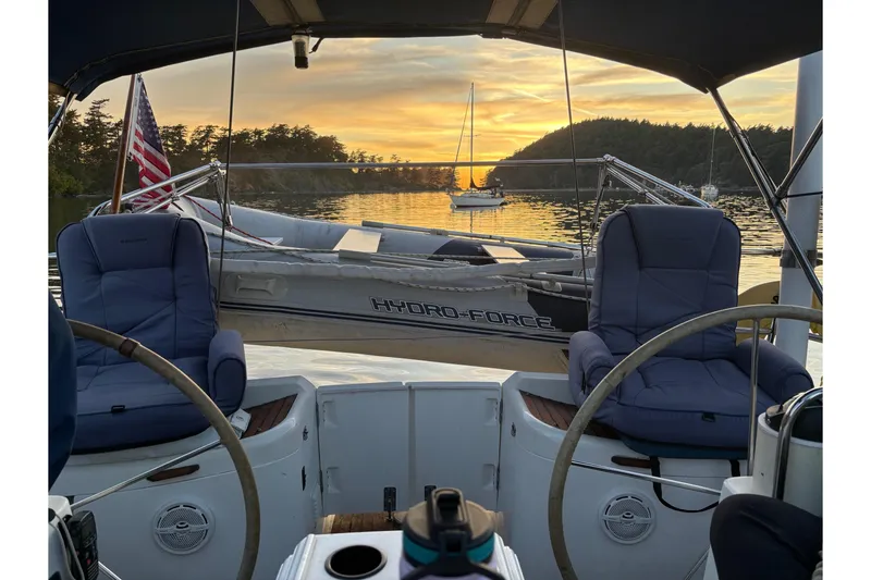 Slide: The Image of Cockpit view of 2001 Jeanneau Sun Odyssey 45.2 sailboat at sunset, with serene water backdrop. - 42