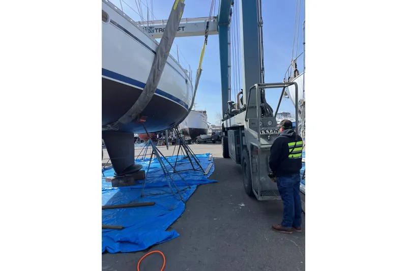 Slide: The Image of Jeanneau Sun Odyssey 45.2 sailboat from 2001 being lifted by a crane at a shipyard. - 44
