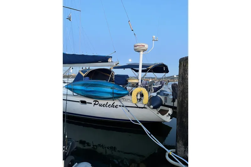 Slide: The Image of Jeanneau Sun Odyssey 45.2 sailboat docked, featuring blue covers and a kayak on deck. - 46
