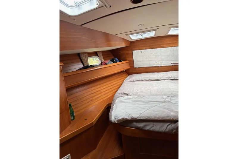 Slide: The Image of Interior cabin of 2001 Jeanneau Sun Odyssey 45.2 yacht, featuring wooden finish and cozy bedding. - 6
