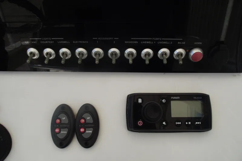 Slide: The Image of Control panel of a 2016 Sportsman Open 212 Center Console with switches and a Fusion stereo. - 19