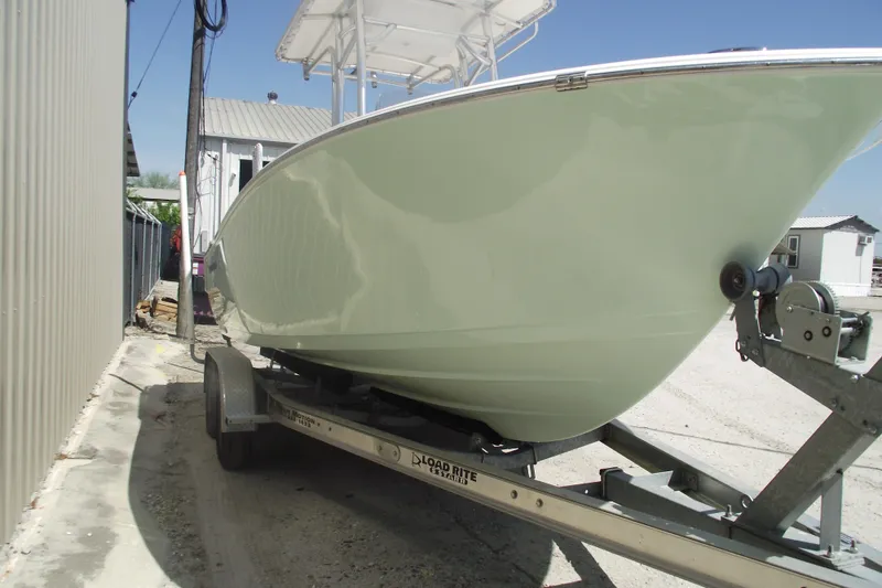 Slide: The Image of 2016 Sportsman Open 212 Center Console boat on trailer, parked outdoors. - 2