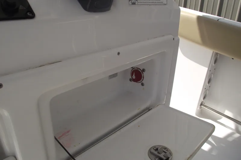 Slide: The Image of 2016 Sportsman Open 212 Center Console interior compartment with latch and control knob. - 30