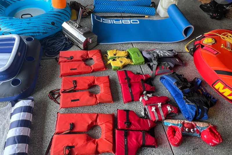 Slide: The Image of Assorted boating gear including life jackets, inflatables, and mats for a 2006 Crownline 252 EX. - 12