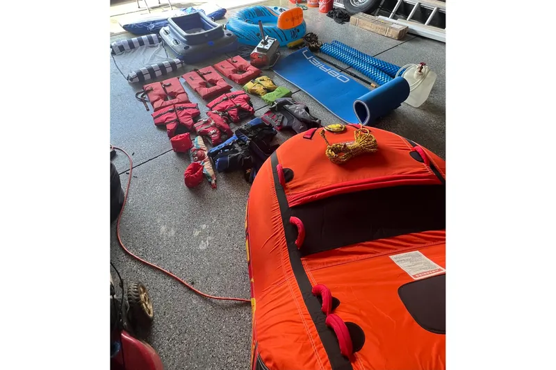 Slide: The Image of Boating gear and life jackets organized in a garage, featuring a 2006 Crownline 252 EX. - 13