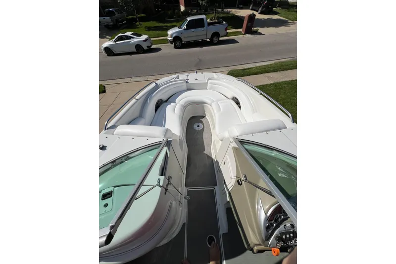Slide: The Image of 2006 Crownline 252 EX boat with spacious seating, parked on a residential street. - 5
