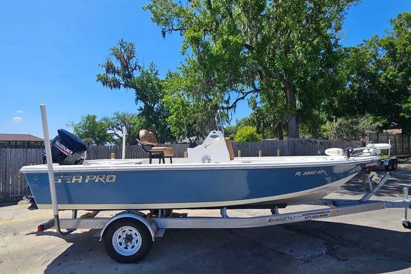 Slide: The Image of 2019 Sea Pro 208 Bay boat on trailer, parked outdoors with trees in background. - 5