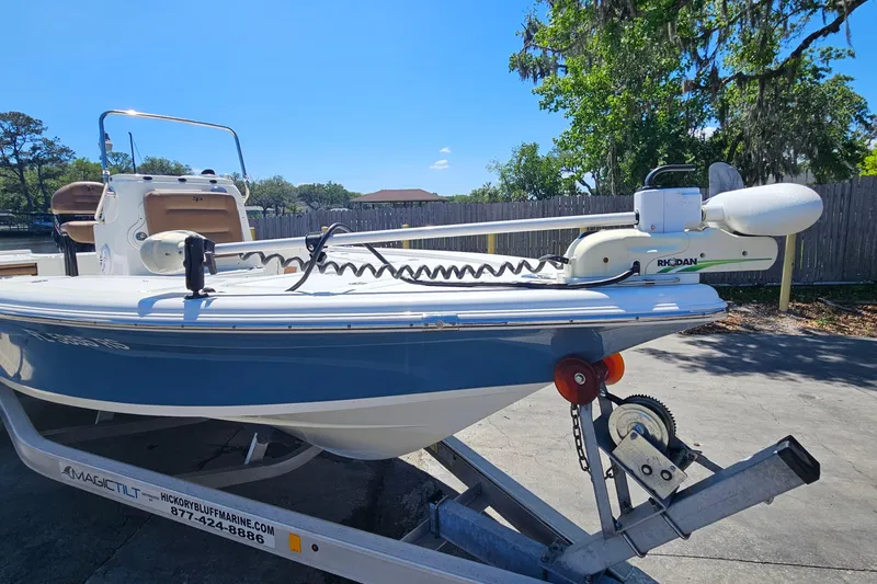 Slide: The Image of 2019 Sea Pro 208 Bay boat on trailer, featuring a trolling motor, under clear blue sky. - 7