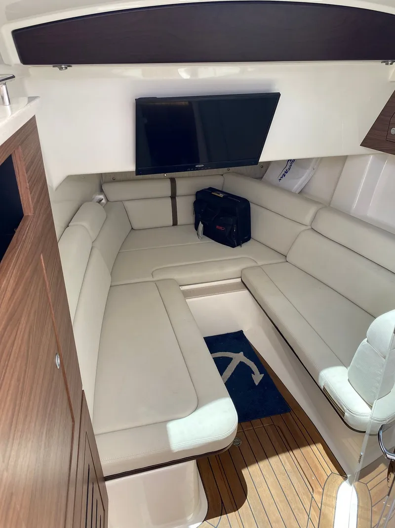 Slide: The Image of Interior of 2020 Boston Whaler 350 Realm with beige sofa and TV. - 17