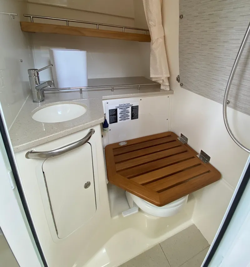 Slide: The Image of Interior of 2020 Boston Whaler 350 Realm with bathroom and wooden seat. - 21