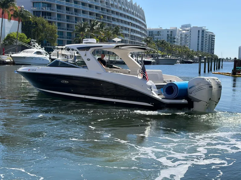 Slide: The Image of 2023 Sea Ray SLX 350 Outboard on water with modern buildings in background. - 18