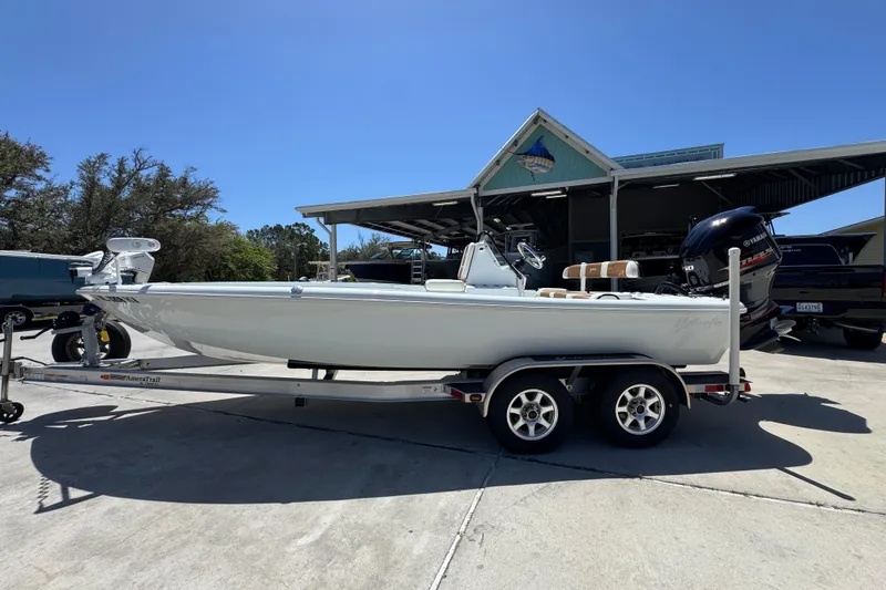 The Image of 2016 Yellowfin 21 Hybrid boat on trailer, parked outdoors under clear blue sky. - 1